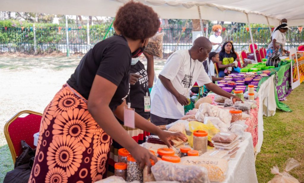 Une femme dispose des produits alimentaires transformés sur un étal, lors d'une foire.